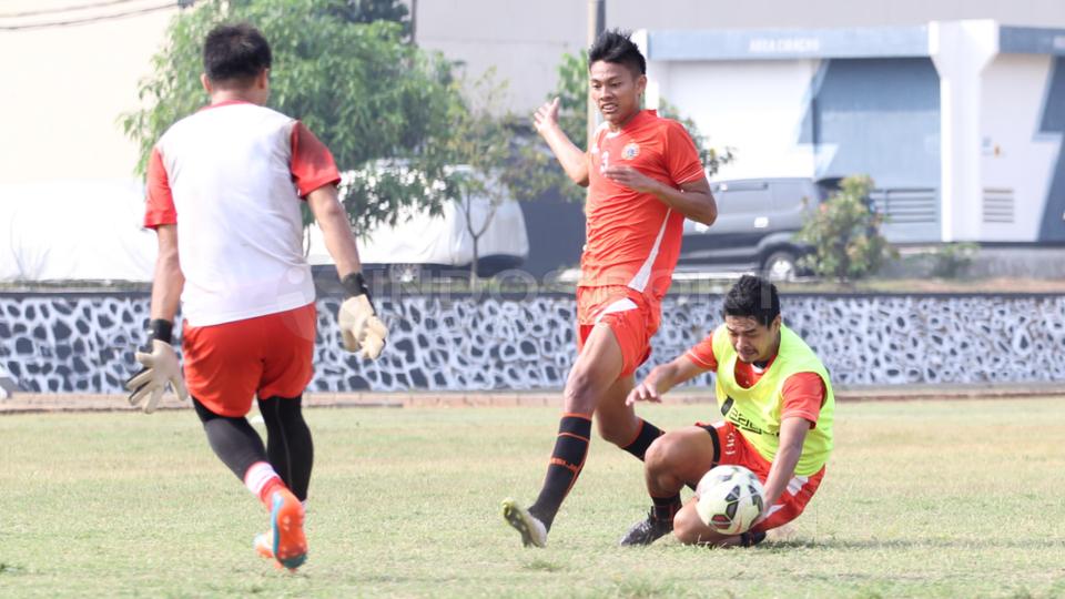 Bambang Pamungkas (kanan) terjatuh saat berduel dengan rekannya.